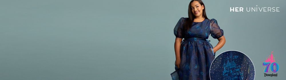 Woman smiling in Disneyland 70th anniversary crewneck sweatshirt with retro logo and red sunglasses.