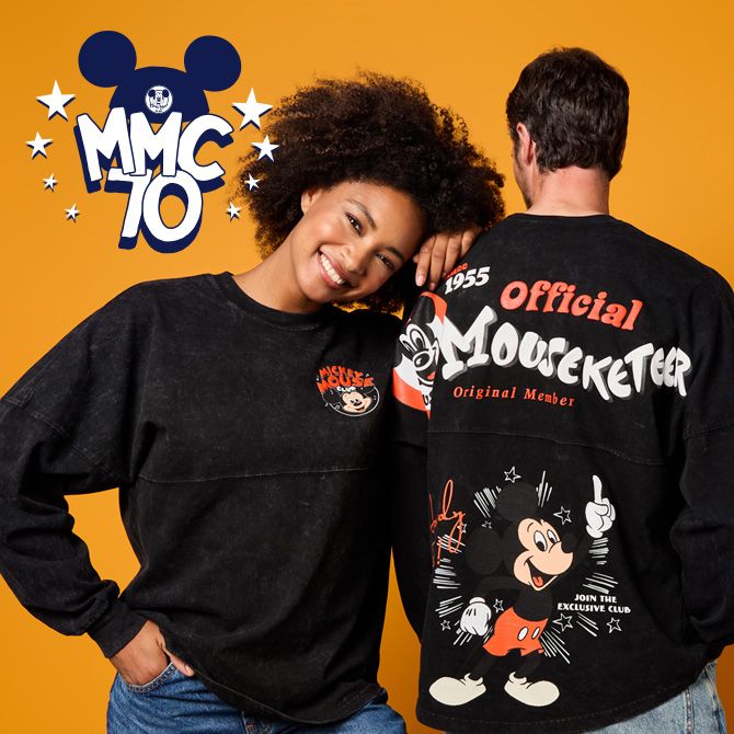 Two individuals wearing black Mouseketeer-themed sweatshirts featuring Mickey Mouse graphics. Bold 'MMC 70' logo in the background.