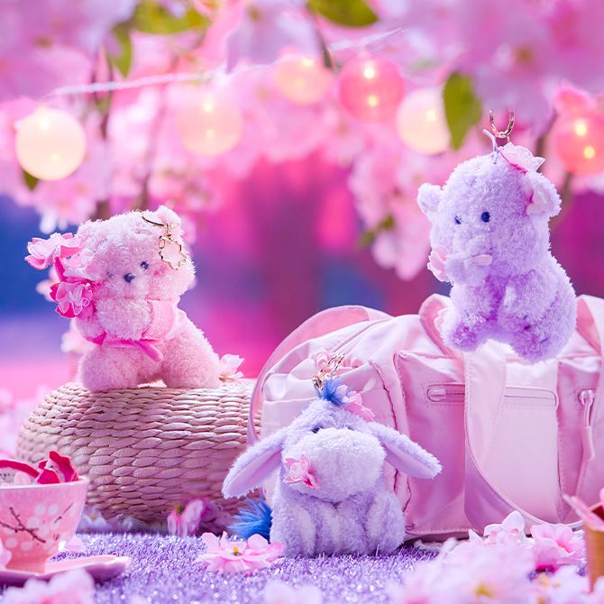 Rex, Lotso, Alien, and Buzz Plush keychains attached to a brown backpack on a yellow background.