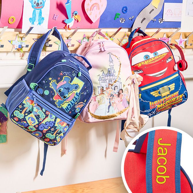 Pink Disney Princess backpack, lunchbox, and water bottle set on a picnic table with snacks. Ariel doll seen sticking out of backpack.