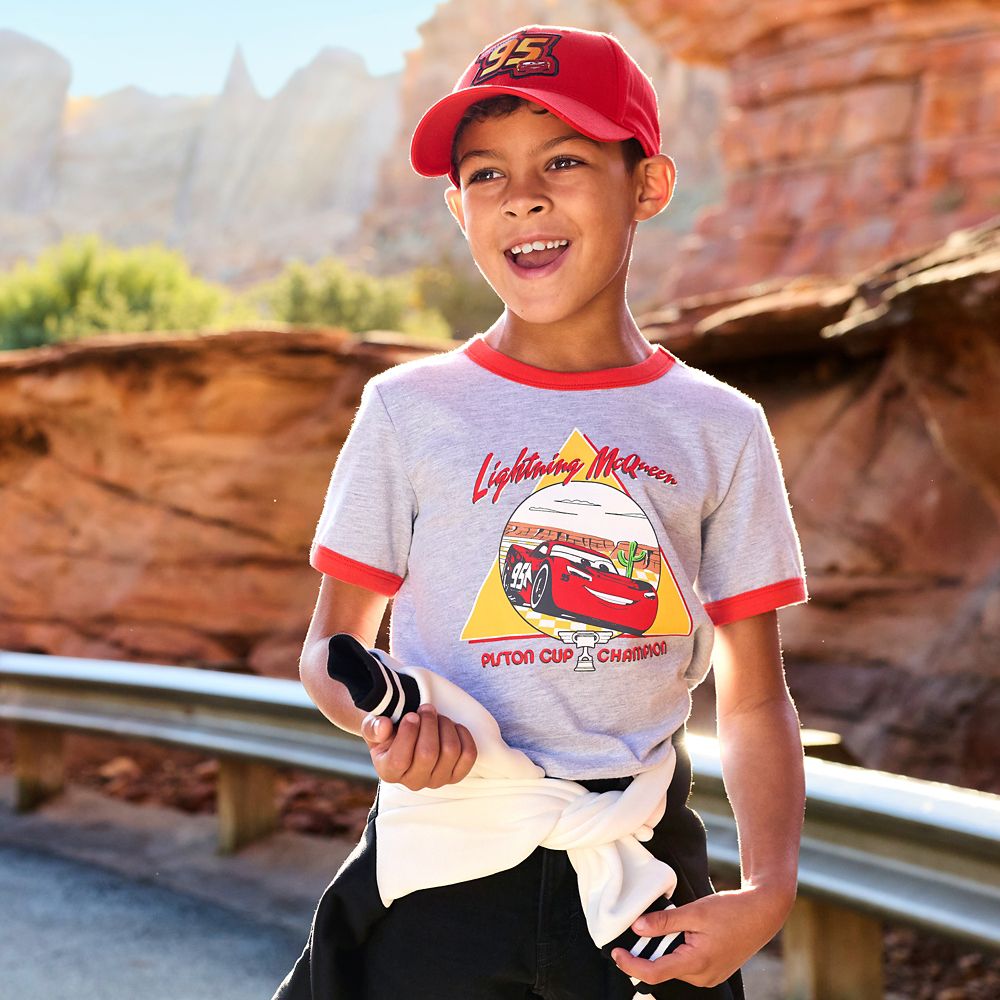 A boy standing outside in a Lightning McQueen Spirit Jersey.