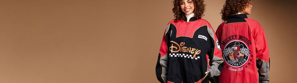 Couple in matching Ice Cream Sandwich Spirit Jerseys. Man showing back with "Disneyland Resort" text. Woman in light green Spirit Jersey with brown detail.