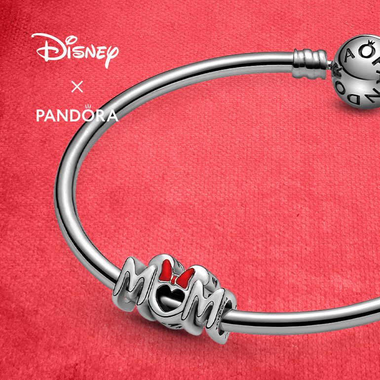Silver Pandora bracelet featuring a "Mom" charm with a Minnie Mouse bow over the O. Text: Disney X Pandora.