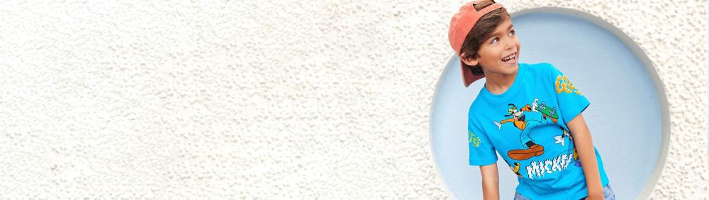 Young boy wearing a black and blue Stitch t shirt with text "OUTTA THIS WORLD".